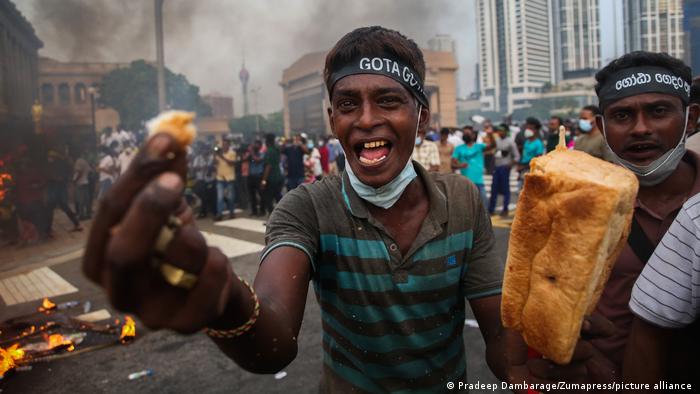 Один із протестувальників у Шрі-Ланці показує в камеру шматок хліба, 15 березня 2022 року
