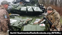 Украинские военнослужащие у поврежденного российского танка Т-72БЗ