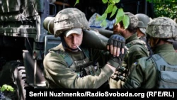 Украинские военнослужащие готовят снаряды для стрельбы из американской гаубицы M777 вблизи линии фронта Донецкой области, 6 июня 2022 года