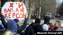 Люди стоят перед военными России во время митинга против российской оккупации.  Херсон, 14 марта 2022 года