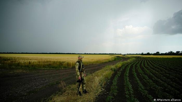 Російський військовослужбовець поряд із пшеничним полем у Запорізькій області України