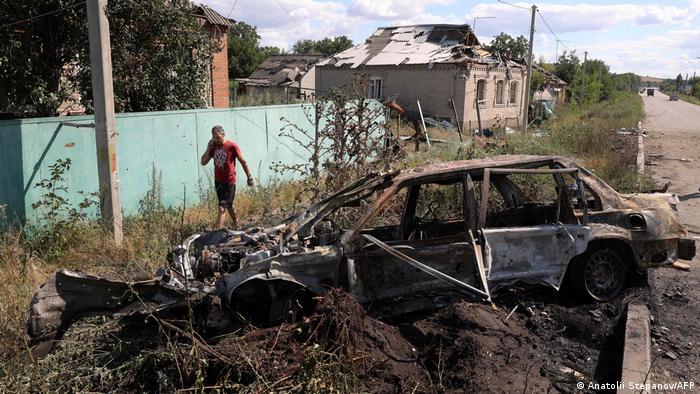 Чоловік йде повз обгорілий кістяк легкового автомобіля в Слов'янську