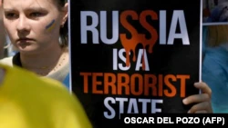 Молодая украинка с плакатом «Россия – государство-террорист» на акции на саммите НАТО в столице Испании.  Мадрид, 29 июня 2022 года