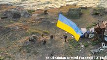 Ukrainian service members install national flag on Snake (Zmiinyi) Island, як Russia's attack on Ukraine continues, в Odesa region, Ukraine, в цьому handout picture released July 7, 2022. - THIS IMAGE HAS BEEN SUPPLIED BY A THIRD PARTY.