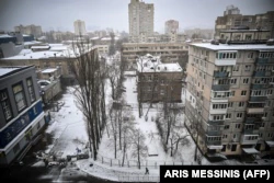 Мужчина идет по покрытому снегом тротуару на пустой улице в Киеве 1 марта 2022 года.  Россия вторглась в Украину за неделю до этого