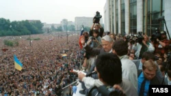 Выступление президента России Бориса Ельцина на митинге в Москве, 20 августа 1991 года.  На митинге развеваются и украинские флаги, на переднем плане – сине-желтый флаг, а на заднем – красно-черный.  Украинцы активно участвовали в массовых акциях в Москве, которые, в конечном итоге, привели к распаду советской империи.  В частности, с 1989 года в Москве действовала организация под названием «ОУН-ДВИЖЕНИЕ»