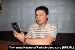 Адвокат Дмитрий Гладкий показывает программу eyeWitness to Atrocities на своем мобильном