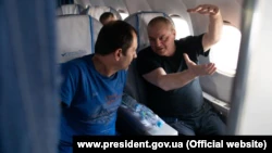 Освобождены во время обмена пленными Владимир Балух и Эдем Бекиров (справа) на борту самолета перед приземлением в киевском аэропорту, 7 сентября 2019 года