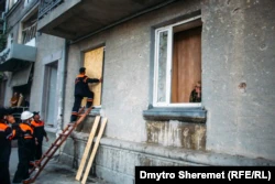 Разбитые окна из-за обстрелов в Николаеве закрывают фанерой, 22 сентября 2022 года