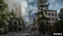 Дым над остатками здания, разрушенного в результате удара РФ по Лисичанску, 17 июня 2022 года
