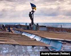 Украинские бойцы устанавливают флаг Украины в освободившемся поселке городского типа Высокополье в Херсонской области, 4 сентября 2022 года