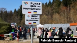 Польша.  Украинские беженцы во время массового вторжения России в Украину прибывают в пункт приема на пограничном пункте пропуска в Кросценко, Польша, 17 марта 2022 года