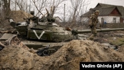 Украинский военнослужащий на танке российской армии с отметкой «V» в селе Андреевцы Киевской области после освобождения села