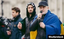 Ахмед Закаев, глава правительства Чеченской Республики Ичкерия в экзилии, с украинским флагом во время акции протеста против российского вторжения в Украину.  Лондон, 5 марта 2022 года