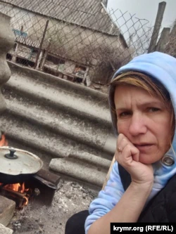 Алла Веселовская, готовит еду на костре во время русской оккупации.  Высокополье